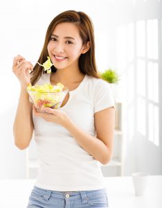 beautiful young woman eating healthy food