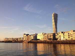 The apartments and Turning Torso sky scraper in Vastra Hamnen Western Harbour at a golden sunset in Malmo Sweden.